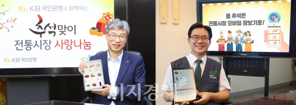 허인(왼쪽) KB국민은행장과 유원신 기아대책 회장이 22일 전통시장 모바일 장보기 어플리케이션(앱)을 통해 어려운 이웃에게 전달할 선물을 구입하고 기념촬영을 하고 있다. 사진=KB국민은행