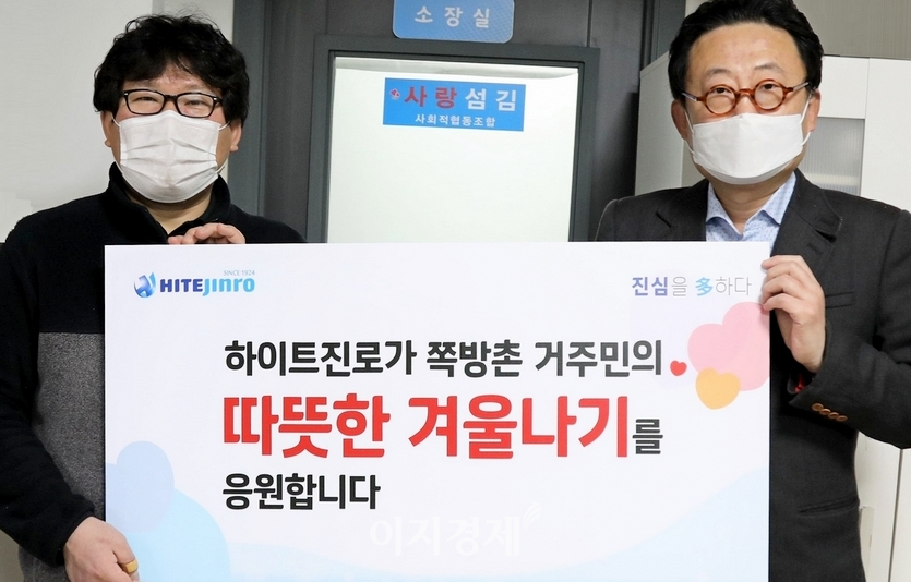 김형옥(왼쪽) 쪽방상담소 소장과 류준형 하이트진로 상무가 1월25일 서울 영등포 쪽방상담소에서 쪽방촌 거주민을 위한 떡과 핫팩 전달식을 하고 기념 촬영을 하고 있다. 사진=하이트진로
