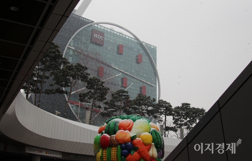 서울 삼성동 코엑스 지하철9호선 출입구에서 현대산업개발 사옥을 잡았다. 내리는 눈이 플라스틱 과일 조형물에 쌓이고 있다. 사진=김보람 기자