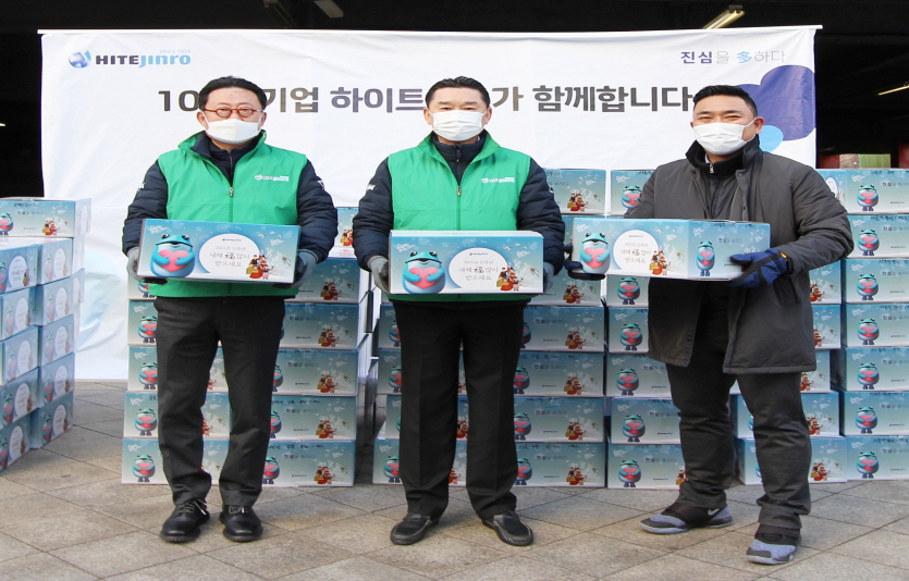 김인규(가운데) 하이트진로 대표가 2월2일 서울 서초구 본사 사옥 앞에서 34개 사회복지기관에 가래떡과 만두 약 1만인분을 전달했다. 사진=하이트진로