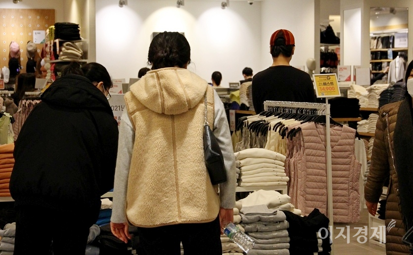 (위부터)이날 낮 최고 기온이 10도 이상을 기록하자, 의류점에도 고객이 몰렸다. 두명의 20대 남성이 옷을 샀는지 쇼핑백을 들고 걸어가고 있다. 사진=김보람 기자