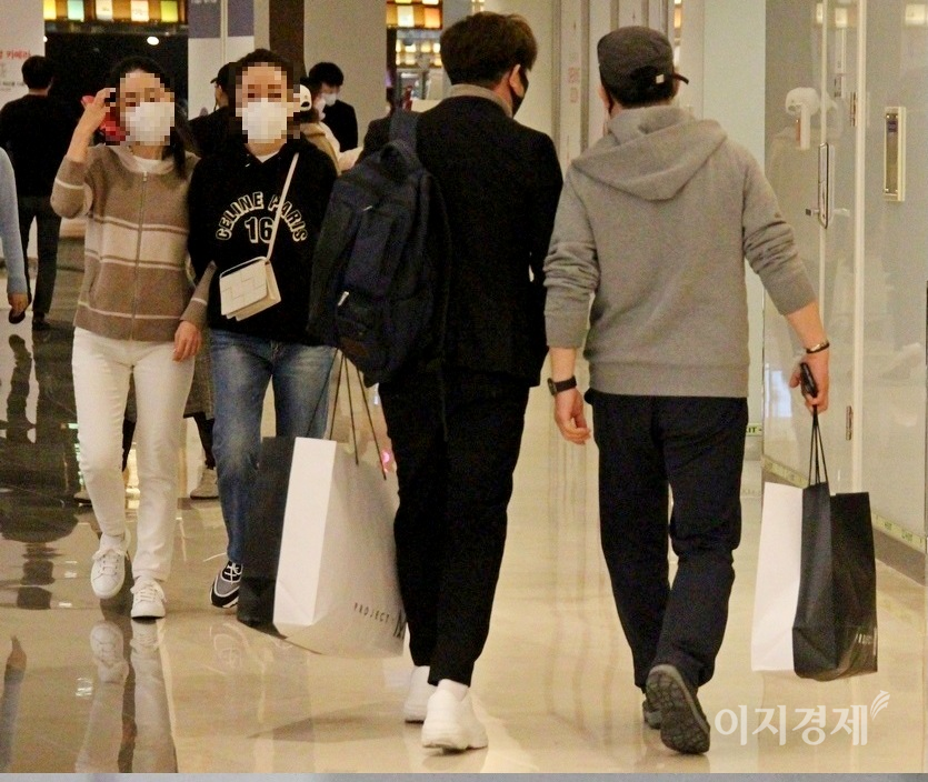 (위부터)이날 낮 최고 기온이 10도 이상을 기록하자, 의류점에도 고객이 몰렸다. 두명의 20대 남성이 옷을 샀는지 쇼핑백을 들고 걸어가고 있다. 사진=김보람 기자