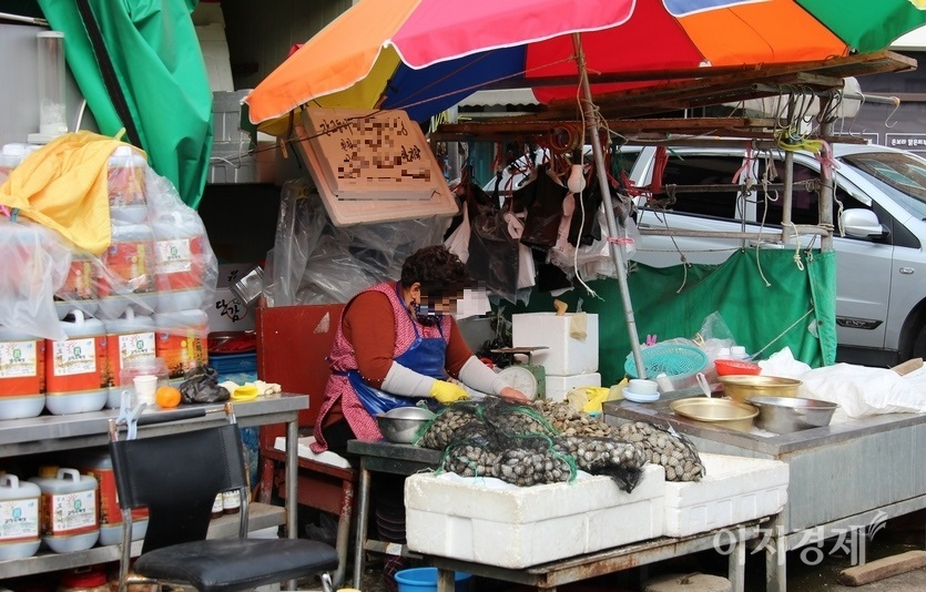 상설시장에 입점하지 못한 해산물 노점상의 주인 역시 애꿎은 바지락만 까고 있다. 사진=김보람 기자