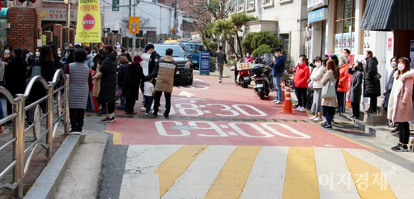 길 건너에도 아이를 데리러 온 학부모가 많다. 아래 사진에서 차량 왼쪽 옆 남자는 학교 보안관으로 유사시를 대비해 학부모와 아이들 주변에 머물러 있다. 사진=양지훈 기자