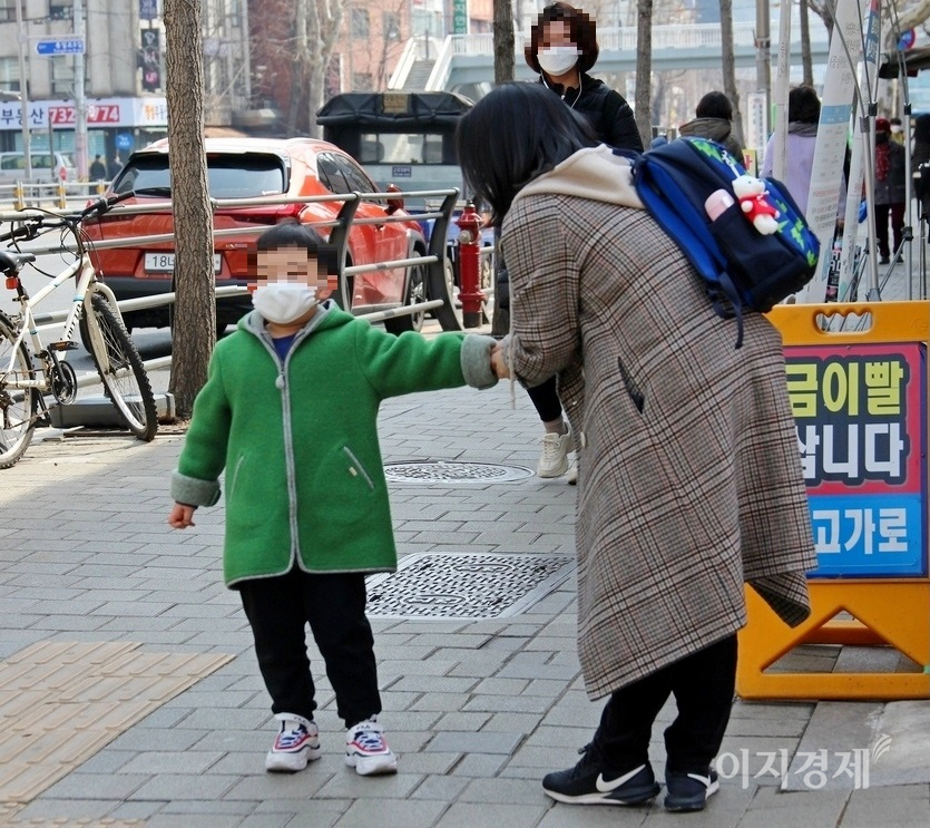 아이를 맞이한 한 엄마가 아이에게 학교생활이 어땠는지 묻자, 아이는 시큰둥하다. 사진=양지훈 기자