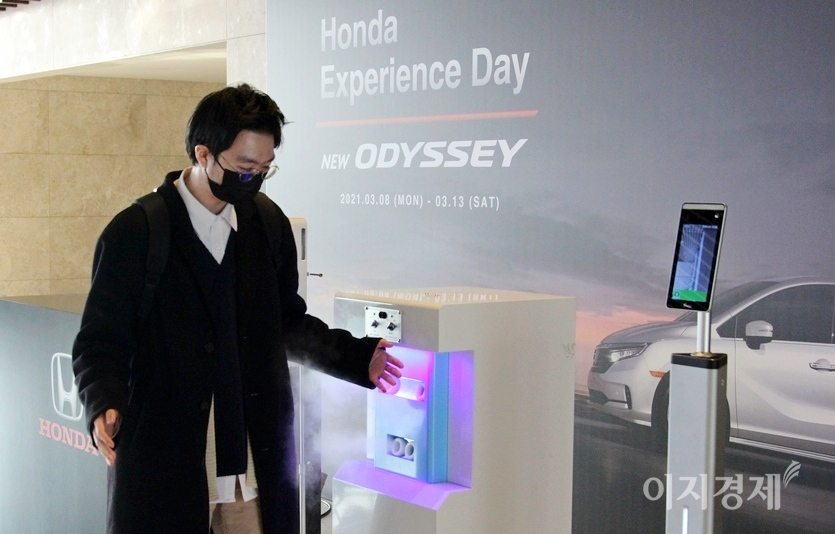 경기도 양평의 한 호텔 행사장에서 본지 이민섭 기자가 직접 디지털 체온계를 통한 발열 여부를 확인한 이후, 의류와 손 등을 소독하고 있다. 사진=정수남 기자