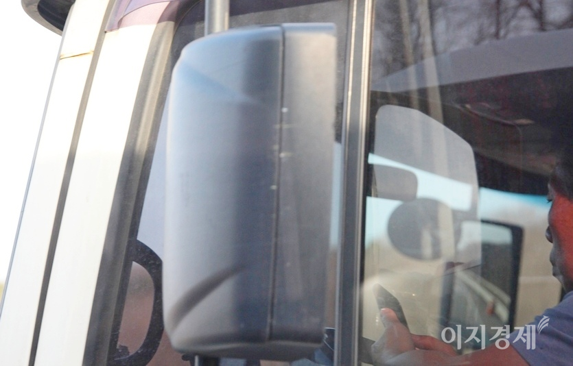 지난주 대형 트럭 운전자가 경부고속국도를 시속 100㎞로 달리면서 스마트폰을 이용하고 있다. 운전 중 스마트폰 사용은 음주와 졸음 운전처럼 집중력 저하로 대형 사고의 원인이 된다. 사진=이민섭 기자