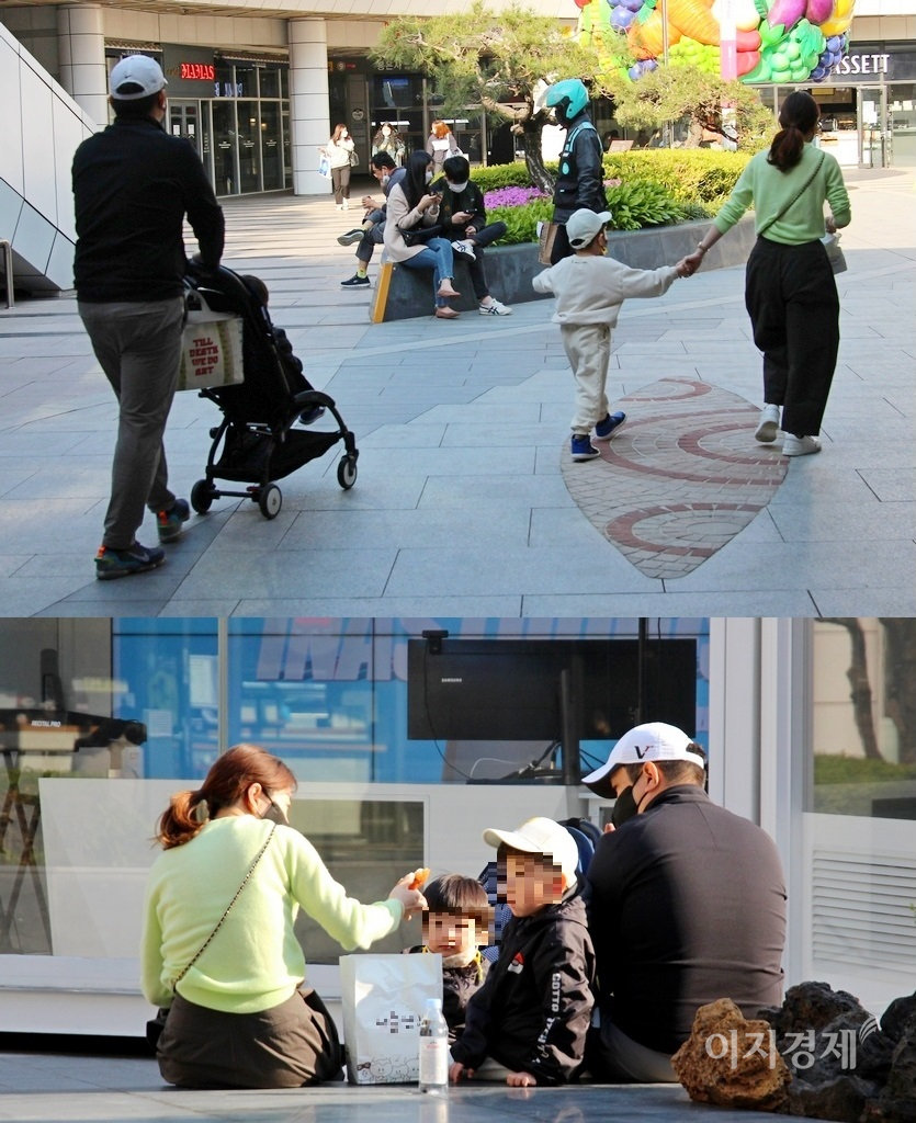 두 아이와 함께 외출한 30대 부부가 유동인구가 많은 지하철 입구에서 간식 등을 먹고 있다. 사진=김보람 기자