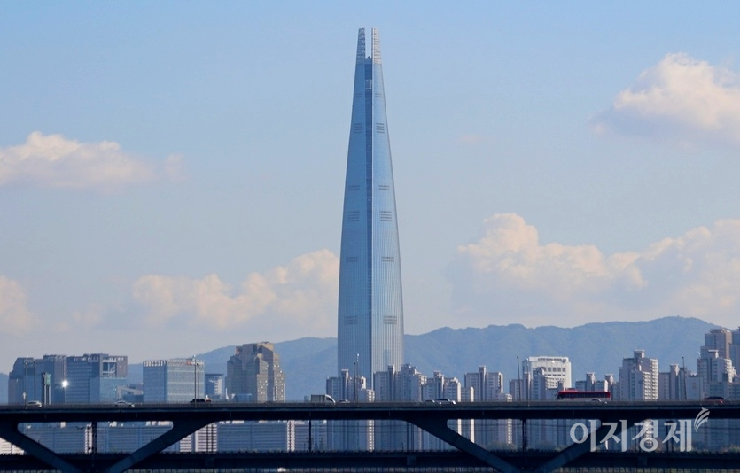 롯데쇼핑은 계열회사인 롯데물산에 서울 송파구 롯데월드타워‧롯데월드몰 소유권 지분 등을 8312억9600만원에 양도한다고 22일 공시했다. 서울 영동대교에서 본 제2 롯데타워와 청담대교. 사진=양지훈 기자