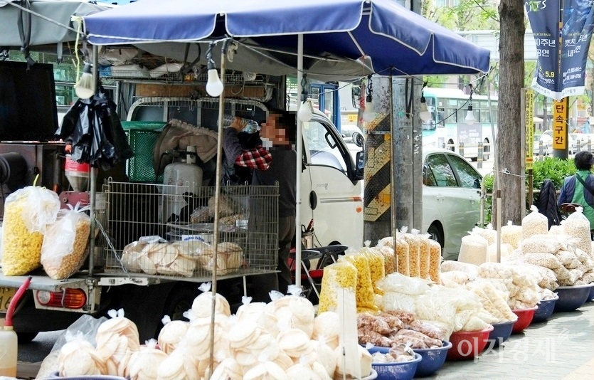 매 주말 수정로 인도에 자리를 펴는 뻥과자 트럭. 손님이 없자 주인이 물을 들이키고 있다. 사진=정수남 기자
