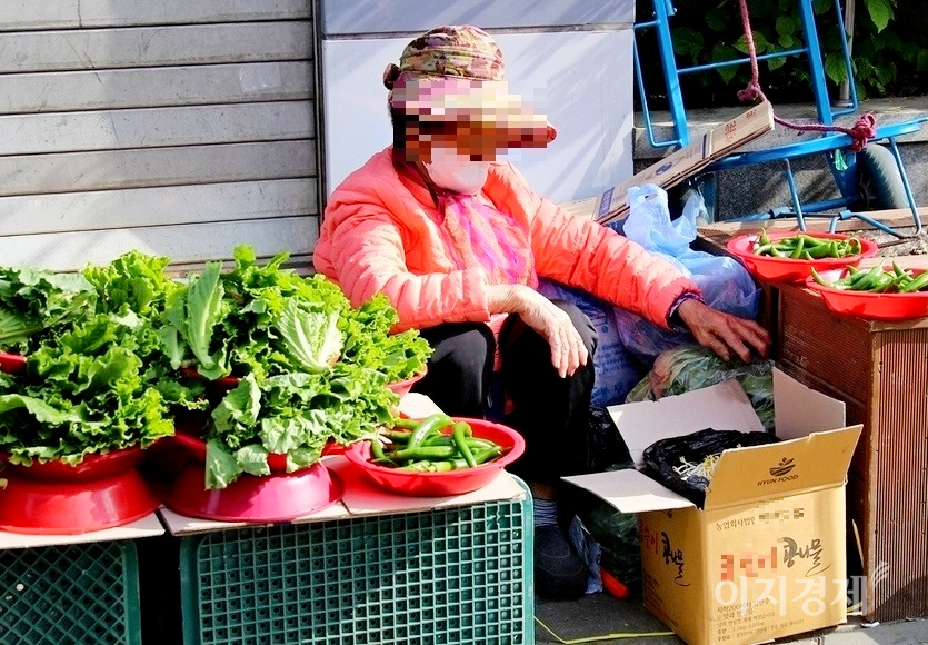 70대 노점상이 손님이 없자 애먼 콩나물만 바라보거나,