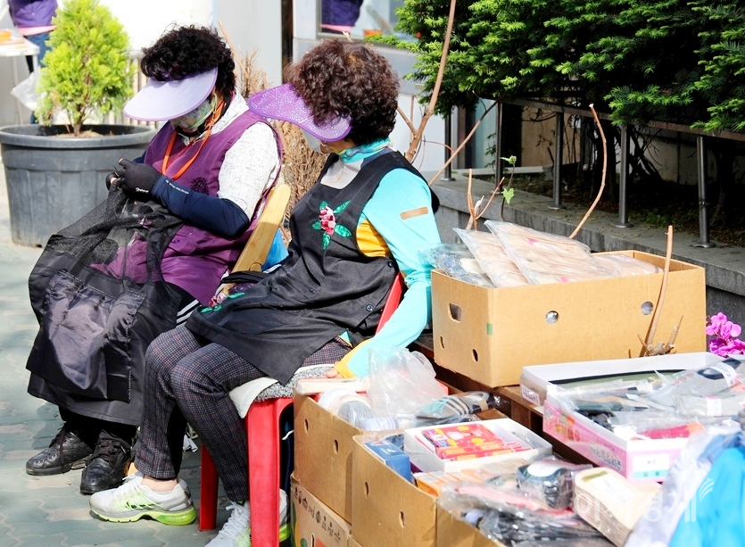 잡화를 판매하는 노점상은 장사를 포기하고 뜨개질을 하고 있고, 봄나물과 건미역을 파는 노점상은 먼산 바라보기를 하고 있다. 사진=이상 정수남 기자