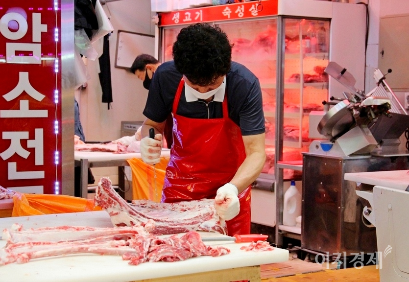 현대시장에 있는 정육점 주인은 손님이 없어, 뼈 갈무리에 여념이 없다. 사진=정수남 기자