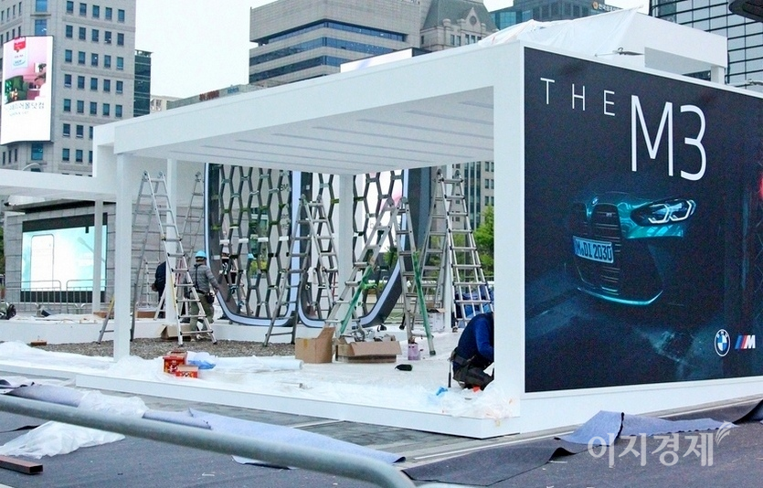 BMW가 지난달 국내 선보인 스포츠 세단 M4와 M3의 대형 홍보부스를 서울 삼성동 SM사옥 앞에 만들고 있다. BMW의 패밀리룩인 대형 키드니그릴이 전시 부스 가운데를 차지하고 있다. 사진=정수남 기자