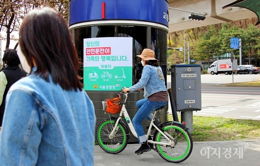 자전거는 도로교통법 규제를 받는 엄연한 자동차다. 이륜차 주행방법 따라 차도 우측으로 주행해야 한다. 한 중년 여성이 자전거를 타고 인도를 달리고 있다. 경찰청이 부착한 이륜차 안전운전 포스터가 무색하다. 사진=정수남 기자