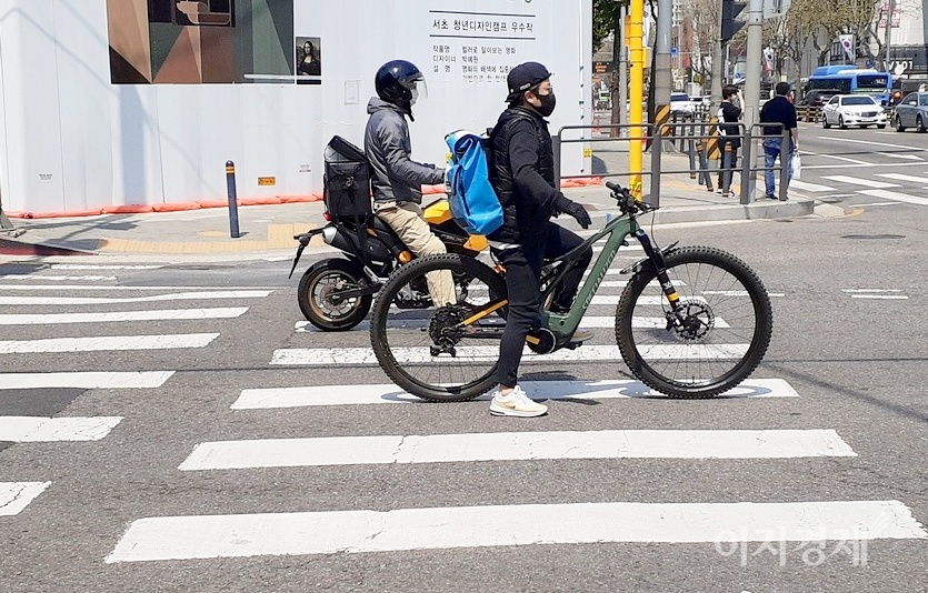 이륜차도 횡단보도 앞에서는 정지선에서 멈춰야 한다. 교통경찰이 인도를 질주한 이륜차 운전자에게 범칙금을 부과하고 있다. 사진=정수남 기자