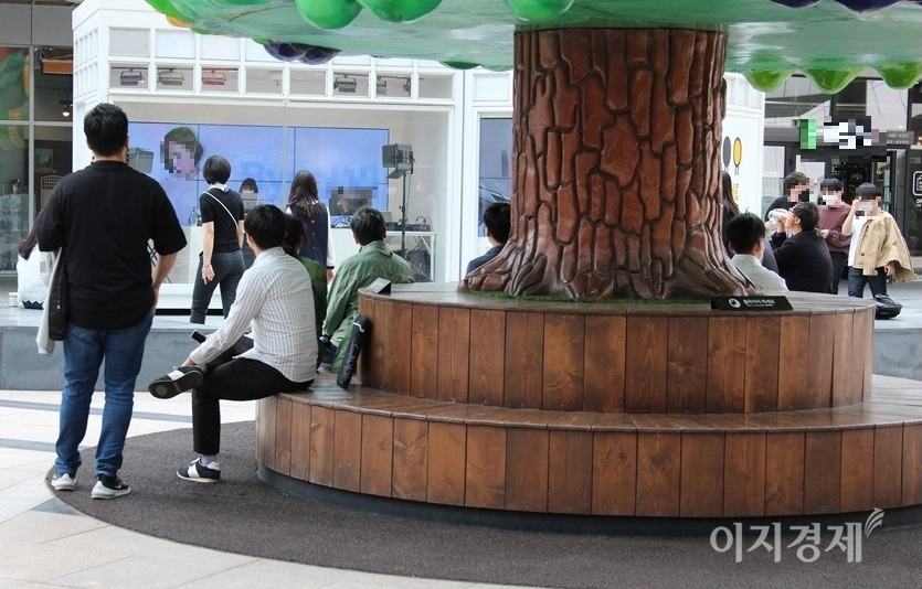 이달 6일 점시시간. 인근에서 일하는 회사원과 행인들이 ‘별OO’의 방송을 듣고 있다. 오른쪽에서 세번째 관객은 마스크를 벋고 음료수를 마시고 있으며, 다른 관객들 역시 거리두기를 무시한 채 앉아 있어 코로나19에 무방비 상태다. 사진=정수남 기자