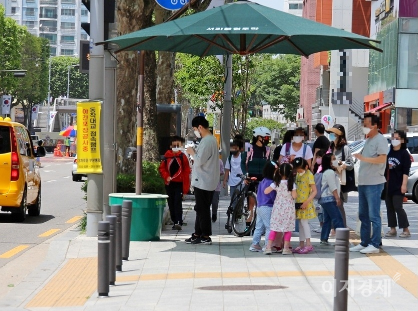 방배로 서래초등학교 앞 횡단보도 그늘막에 초등학생들과 학부모, 행인들이 뒤석여 있다. 사진=정수남 기자