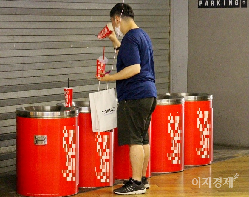 한 30대 남성이 쓰레기통을 뒤져 관람객이 버린 팝콘과 음료수 등을 찾아 먹고 있다. 사진=정수남.