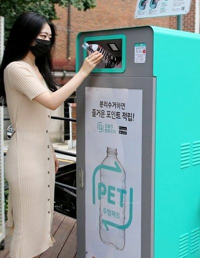 한 여성 고객이 GS25의 AIoT 투명 페트병 수거함에 페트병을 버리고 있다. 사진=GS25