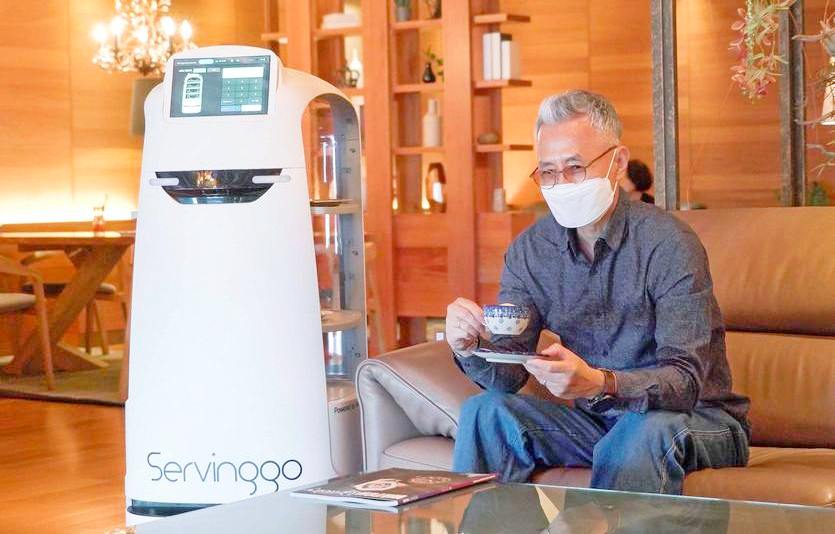 AI 서빙로봇 서빙고가 호텔 이용객에게 음료를 제공하고 있다. 사진=SK텔레콤