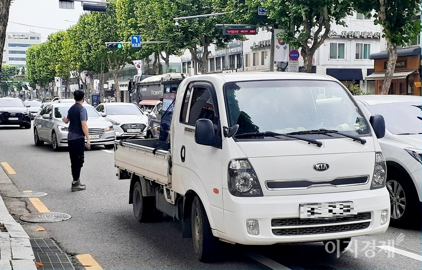 기아차의 1톤 봉고 트럭이 고장으로 편도 2차선 도로, 2차선에 멈췄다. 운전자가 즉시 내려 뒤따르는 차량에 수신호로 우회할 것을 당부하고 있다. 사진=정수남 기자