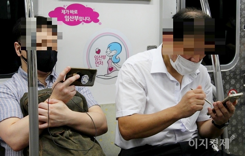 50대의 한 남성이 마스크를 코끝에 건 채 당당하게 임산부 배려석에 앉아 스마트폰을 보고 있다. 사진=정수남 기자