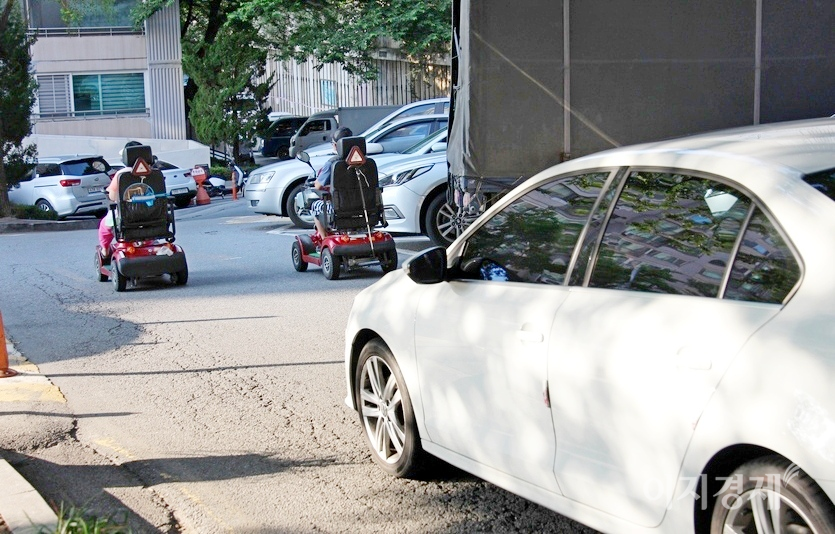 뒤따르는 승용차가 진행을 하지 못해 한참 동안 노부부 뒤를 따라간다. 전동차와 이륜차 등은 도로 우측으로 주행해야 한다. 사진=정수남 기자