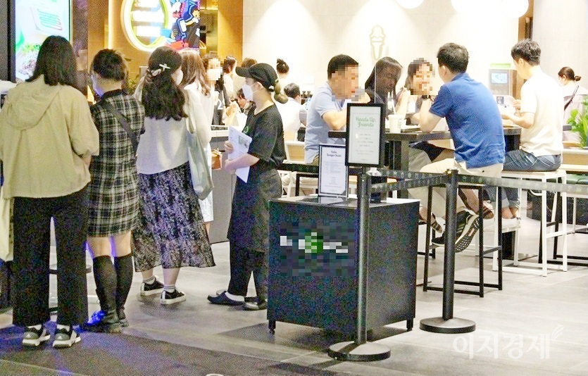 서울 강남의 한 복합쇼핑몰에 있는 패스트푸드점의 28일 점심시간 모습. 직원이 QR코드 입장을 살피고 있지만, 매장 내 거리두기는 없다. 사진=이지경제