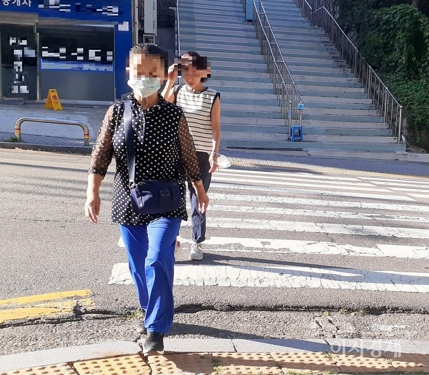 이날 아침 한 70대 노인은 마스크를 착용했으나, 30대 여성은 마스크를 손목에 걸쳤다. 사진=이지경제