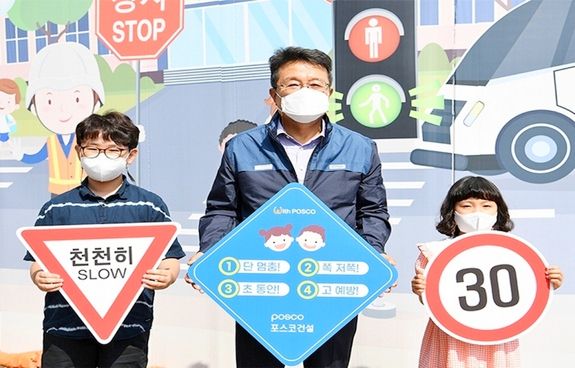 한성희(가운데) 포스코건설 사장이 인천 더샵 송도센터니얼 건설 현장 앞에서 어린이 교통안전 릴레이 챌린지에 참여했다. 사진=포스코건설