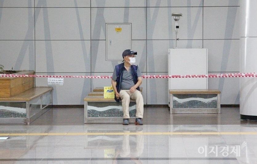 한 80대 노인이 사회적 거리두기와 집합 금지로 이용제한 테이프가 둘러쳐진 벤치에 앉아 다리 쉼을 하고 있다. 사진=정수남 기자