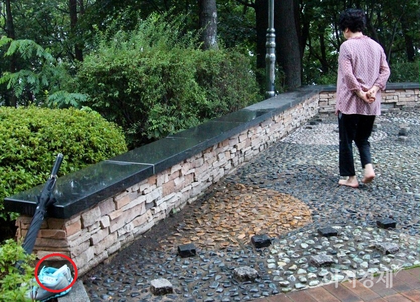 70대 노인이 마스크를 신발에 넣어 둔 채 지압장을 걷고 있다. 사진=정수남기자