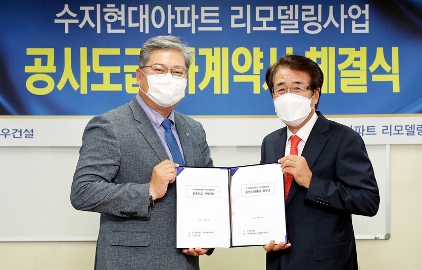 (왼쪽부터)김영일 대우건설 상무와 박생환 수지현대아파트 조합장이 공사도급계약을 체결 후 기념사진을 찍고 있다. 사진=대우건설