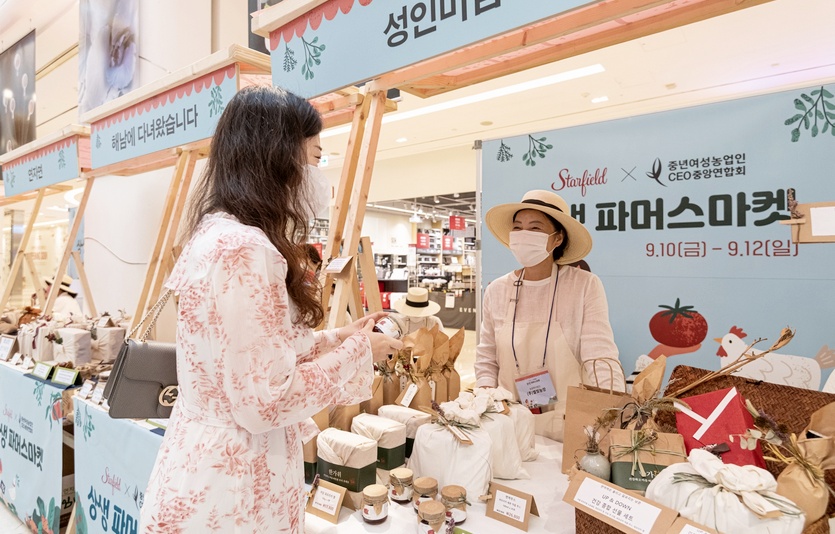 여성 고객이 (위부터)별빛농장의 잼과 주스 등을 구매하고 있다. 사진= 스타필드 하남