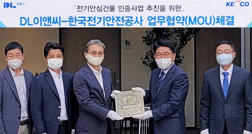 (왼쪽 세번째부터)권수영 DL이앤씨 주택사업본부장과 한국전기안전공사 김권중 기술이사가 전기 안심건물 인증 현판을 주고받고 있다. 사진=DL이앤씨