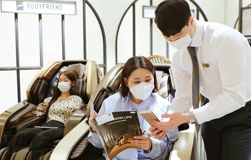 서울 소공동 본점 바디프랜드 매장에서 고객이 안마의자를 체험하고, 구매 상담하는 모습. 사진=롯데백화점