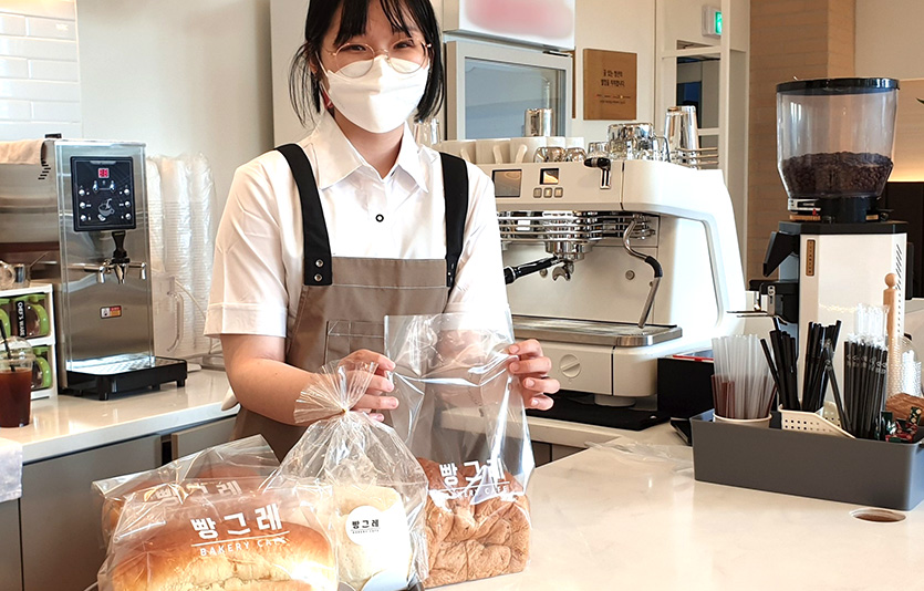 하이트진로는 청년자립 지원 프로젝트 ‘빵그레’ 2호점을 연다. 빵그레 광주점 자활근로 청년 직원이 빵을 포장하고 있다. 사진=하이트진로