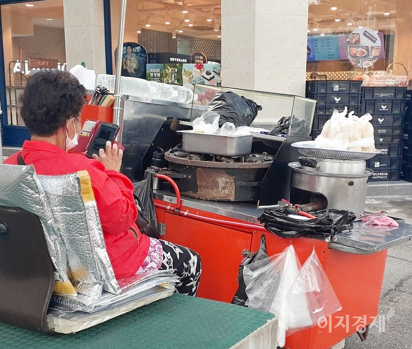경기도 성남시 중원구 산성대로 변에 자리한 노점상 주인이 스마트폰 삼매경에 빠졌다. 사진=정수남 기자