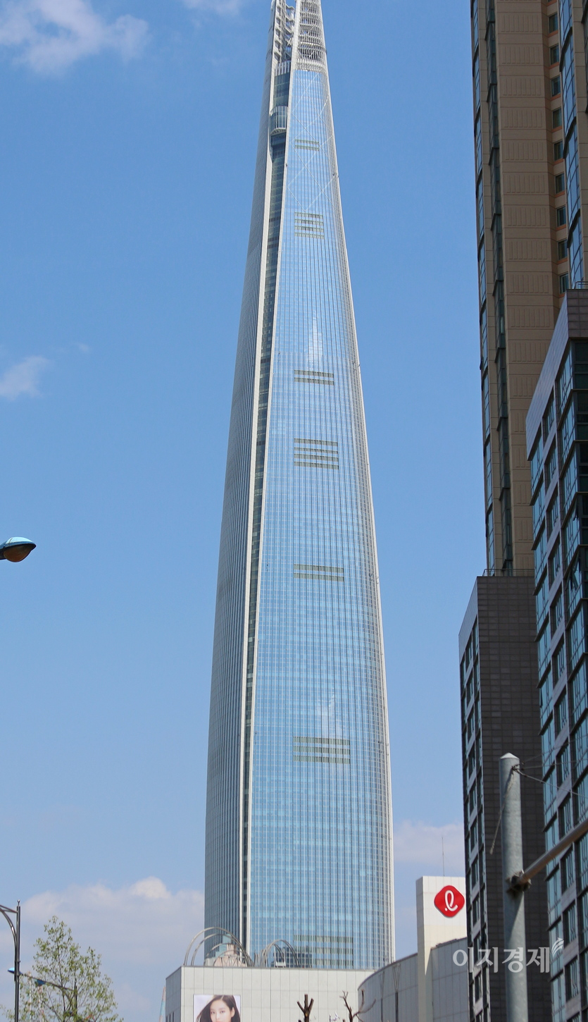 롯데월드타워에서 200여미터 떨어진 롯데백화점 잠실점 인도에서 타워를 잡았다. 사진 왼쪽 아래 알파벨 ℓ을 형상화한 빨간색 롯데 기업이미지가 돋보인다. 사진=정수남 기자