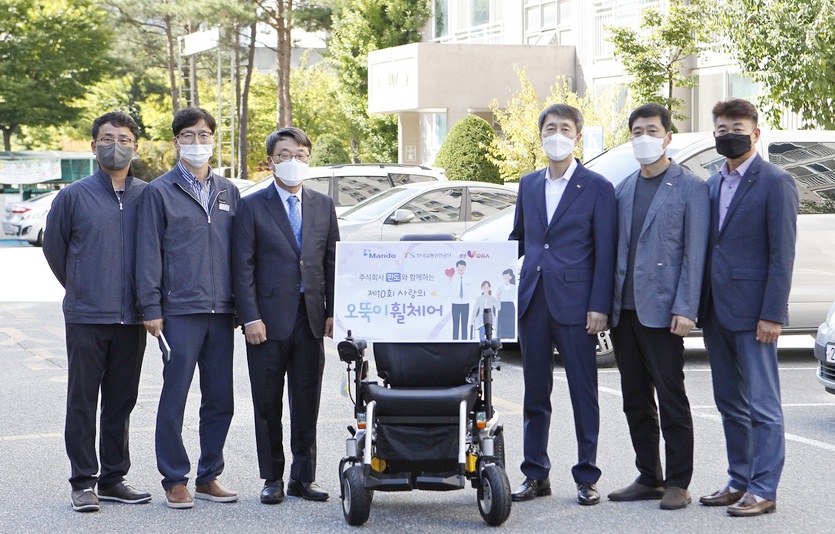 만도 (왼쪽 세번째부터)홍영일 상무와 한국교통안전공단 이장규 강원본부장 등이 강원도 원주시에 거주하는 수혜자 집을 방문해 ‘사랑의 오뚝이 휠체어’를 기증했다. 사진=만도