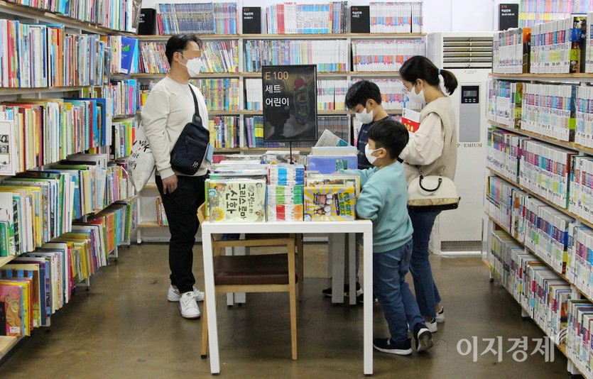 30대 부모가 두 아들과 함께 책을 고르고 있다. 사진=정수남 기자