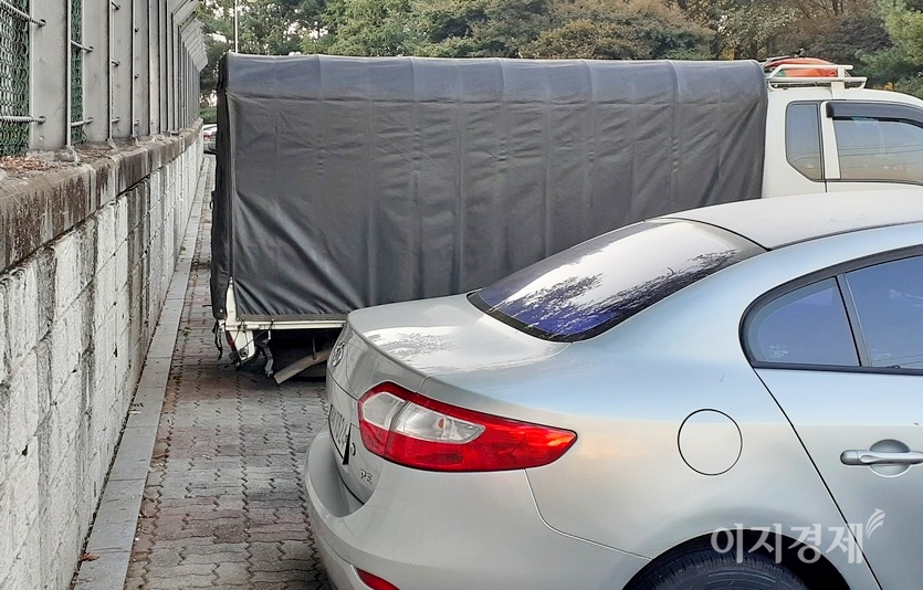 구청이 일렬 세로주차 구획선을 그렸지만, 주민들이 가로주차를 하면서 인도가 막혔다. 사진=정수남 기자