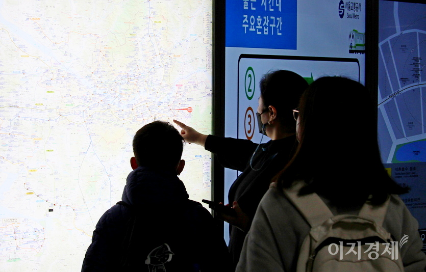 잠시 후 어머니로 보이는 중년 여성이 다가와 자신들이 가야할 역을 짚고 있다. 사진=이승렬 기자