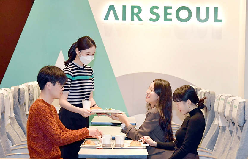 에어서울이 커피빈코리아와 손잡고 ‘커피&여행’ 행사를 전개한다. 에어서울이 커피빈 광화문점에 꾸민 ‘에어서울 커피빈 라운지’를 찾은 고객들이 기내식을 맛보고 있다. 사진=에어서울