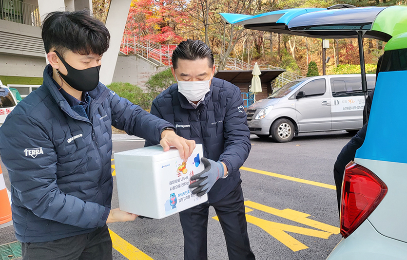 22일 구립서초노인요양센터에서 김인규 하이트진로 대표(오른쪽)가 사회복지기관에 김장김치를 전달하고 있다. 사진=하이트진로