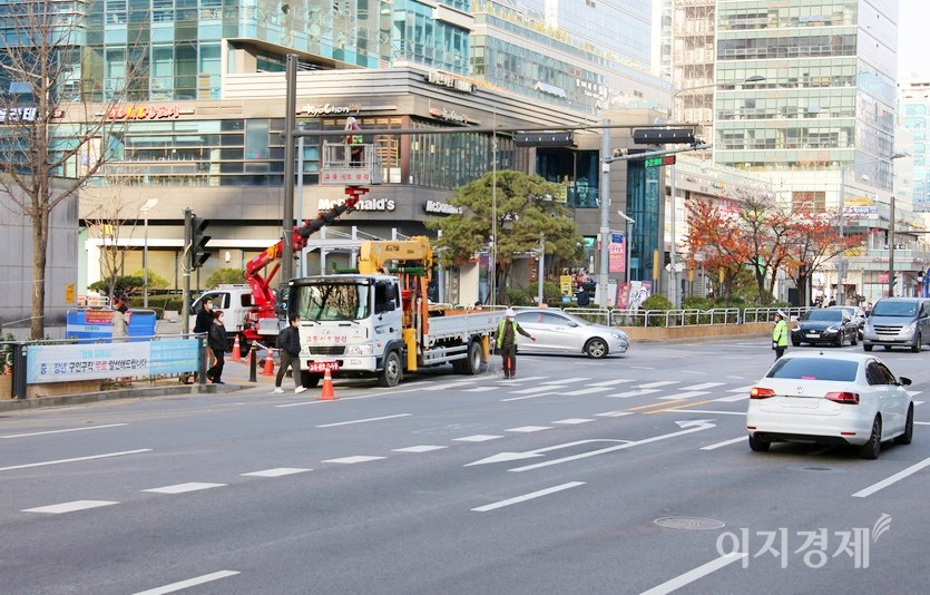 사진 상으로 큰 이상이 없다. 세명의 보행자 위로 교통신호 점검 차량 2대와 점검자가 탄 박스가 보인다. 사진=정윤서 기자