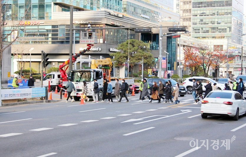오른쪽에서 보행자가 대거 건너면서 보행에 어려움을 겪고 있고, 안전사고에 노출됐다. 박스는 사다라차에 연결됐고, 횡단보도에 주차한 차량은 공사관련 자재차량으로 보인다. 사진=정윤서 기자