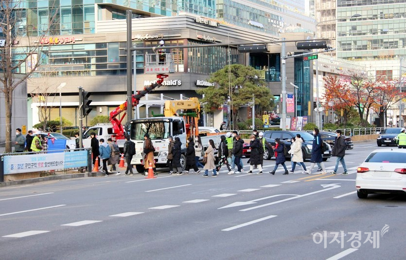 오른쪽에서 보행자가 대거 건너면서 보행에 어려움을 겪고 있고, 안전사고에 노출됐다. 박스는 사다라차에 연결됐고, 횡단보도에 주차한 차량은 공사관련 자재차량으로 보인다. 사진=정윤서 기자