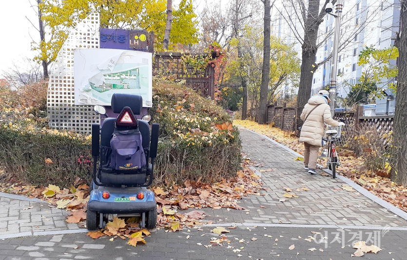 소형 전동차 옆에 한 중년 부인이 자전거를 주차하고 있다. 사진=정윤서 기자